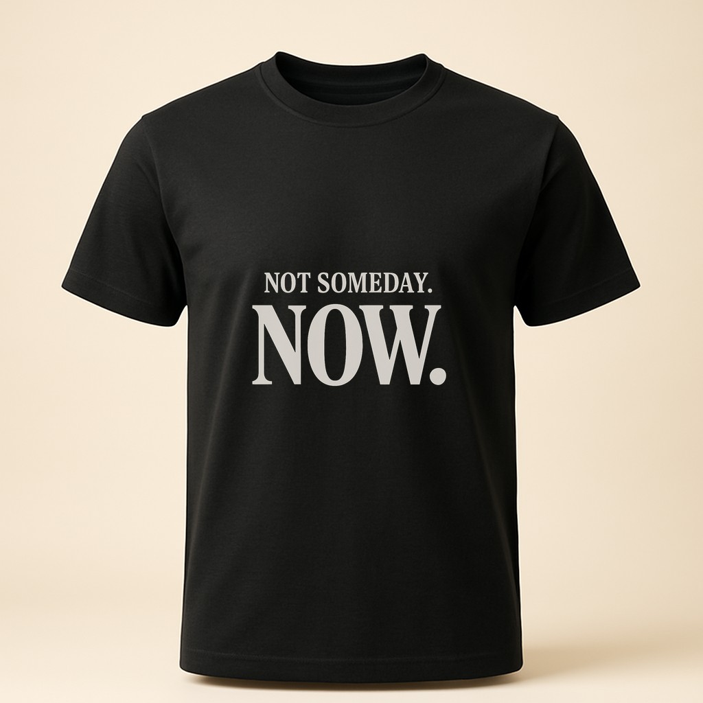 Black tee with large cream serif reading "Not someday. Now."